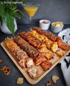 there are many different types of food on the trays next to some drinks and pretzels