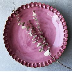 a pink bowl with flowers in it sitting on a table