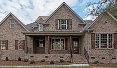 a brick house with lots of windows and shutters on the front door is shown
