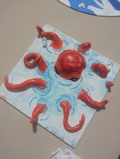 an art project is being displayed on a table with paper and glues to make it look like they are floating in the water