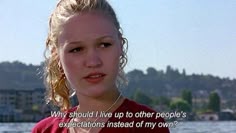 a woman standing in front of the water with a quote on her face that reads, why should i live up to other people's expectations?