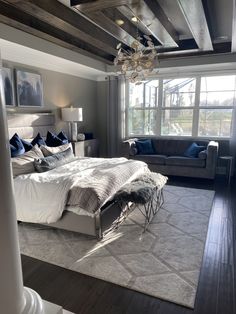 a large bed sitting in the middle of a living room next to a couch and window