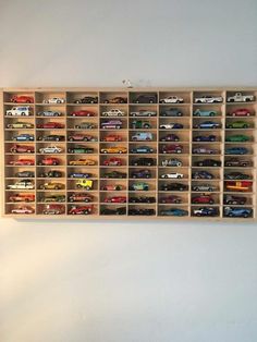 a wooden shelf filled with lots of toy cars