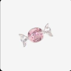 a pink candy with two silver bows on it's head and one is in the shape of a fish