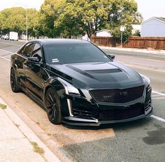 a black car is parked on the side of the road