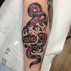 a skull and snake tattoo on the arm