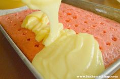 someone is spreading icing on a cake in a pan