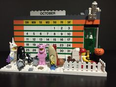 a lego calendar sitting on top of a table next to toy figurines in front of it