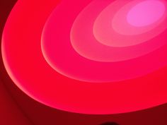 a cell phone sitting on top of a red table next to a light pink wall