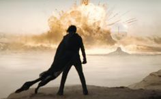 a man standing on top of a sandy beach next to a giant object in the air