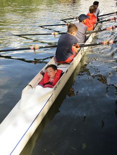 several people in a row boat on the water