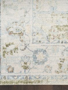 an area rug with various colors and patterns on the wood floor in front of it