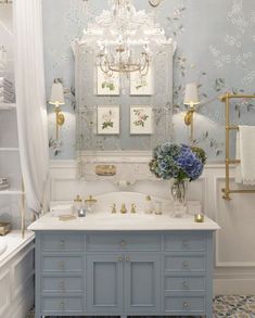 a bathroom with blue and white walls, a chandelier and two sinks in it
