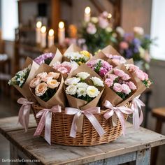 a basket filled with lots of flowers on top of a wooden table next to candles