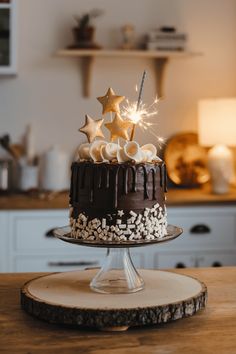 a chocolate cake with white frosting and stars on top, sitting on a wooden table