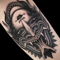 a black and white photo of a demon with its mouth open, on the arm