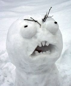 a snowman with its mouth open and eyes wide open, standing in the snow