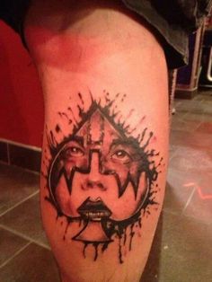 a man's leg with a tattoo on it and an image of a face