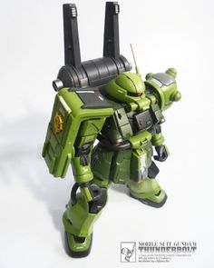 a green and black robot toy on a white background
