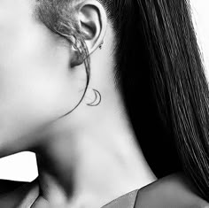 a woman with long hair wearing a neck tie and ear piercings on her ears