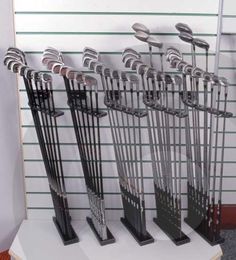 there are many different types of golf clubs on this display stand, all in black and silver