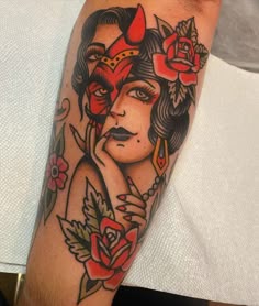 a woman's face with horns and flowers in her hair is shown on the arm
