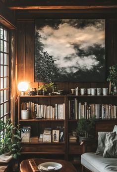 a living room with bookshelves, couch and coffee table in front of a window