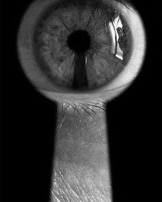 an eye looking through a magnifying glass to see something in black and white