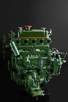 an old green engine on display in front of a black background