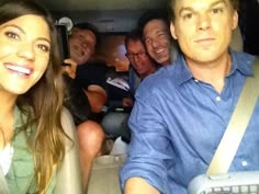 a group of people sitting in the back of a car with one person taking a selfie