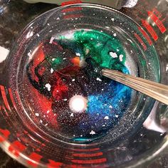 a bowl filled with liquid and spoons on top of a table