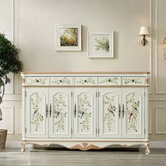 an ornate white sideboard with floral designs on the doors and drawers, in a living room