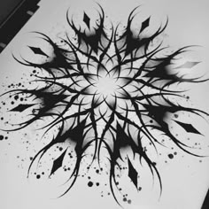 a black and white drawing of an abstract flower with arrows in the center on a sheet of paper
