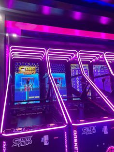 several arcade machines with neon lights on them