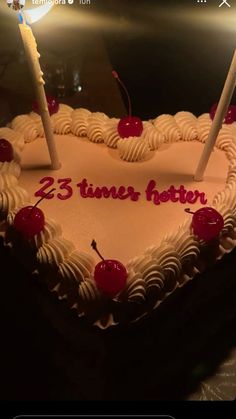 a heart shaped cake with candles on it that says 25 times later and cherries in the middle