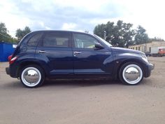 a small blue car parked in a parking lot