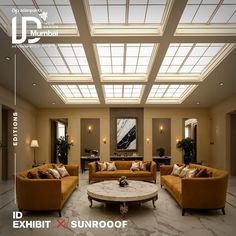a living room filled with lots of furniture under a large skylight over a coffee table