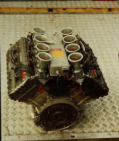 the engine is sitting on top of the metal tray with four cups in it's center