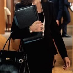 a woman carrying a black briefcase in her hand