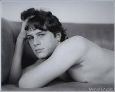 black and white photograph of a man laying on a couch with his hand under his head