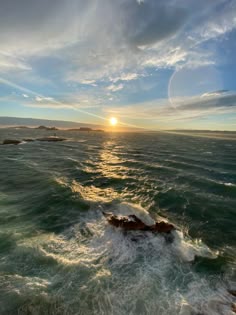 the sun is setting over the ocean as seen from a boat on the water's surface
