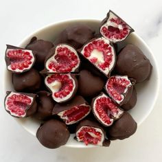 a white bowl filled with chocolate covered pomegranates