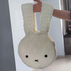 a person holding up a paper bag shaped like a bunny