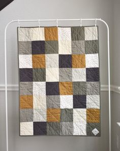 a quilt hanging on a clothes rack in a room
