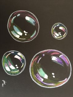 three different colored bubbles on a black surface