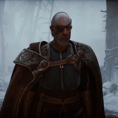 a man with a beard and cape standing in the middle of a snow covered forest