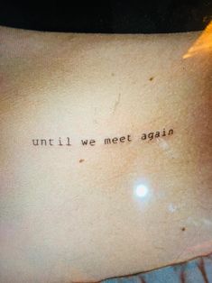 a tattoo saying until we meet again on someone's left side ribcage