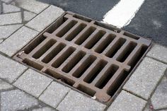 a manhole cover on the ground with white lines painted on it's sides