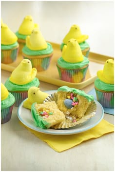 cupcakes with green frosting and yellow chicks on top are sitting on a plate