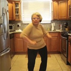 an older woman is standing in the kitchen